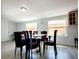 Open dining area featuring a glass table surrounded by modern chairs and well-lit by natural light from two windows at 2035 Vinson Ave, Sarasota, FL 34232