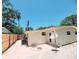 View of the home's exterior with a brick patio, modern AC unit, and well-maintained white walls at 2035 Vinson Ave, Sarasota, FL 34232