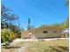 Back exterior of home, featuring a grassy yard and mature trees at 2035 Vinson Ave, Sarasota, FL 34232