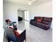 Inviting living room with a plush brown leather sofa, wicker chairs with red accents, and stylish tile flooring at 2035 Vinson Ave, Sarasota, FL 34232