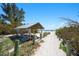 Picturesque beach access path leading to a serene sandy beach with a shaded pavilion at 204 75Th St, Holmes Beach, FL 34217