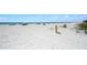 Beautiful beach with soft white sand, clear blue water, and beachgoers in the distance at 204 75Th St, Holmes Beach, FL 34217