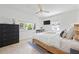 Stylish bedroom with a natural woven bedframe, sleek furnishings, ceiling fan, and ample natural light at 204 75Th St, Holmes Beach, FL 34217