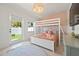 Charming bedroom with stylish decor featuring a bunk bed, decorative wallpaper, and access to the outside at 204 75Th St, Holmes Beach, FL 34217