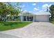 Charming home with a lush green lawn, beautiful landscaping, and inviting front porch seating at 204 75Th St, Holmes Beach, FL 34217