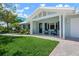 Charming light blue single-story home featuring a well-manicured lawn and inviting front porch with seating at 204 75Th St, Holmes Beach, FL 34217