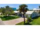 Charming coastal home featuring a paver driveway, a lush lawn, mature landscaping, and a metal roof at 204 75Th St, Holmes Beach, FL 34217