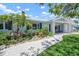 Well-maintained front yard featuring lush landscaping, white gravel accents, and a light blue home at 204 75Th St, Holmes Beach, FL 34217