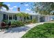 Landscaped front yard featuring a stone pathway, vibrant plants, and well-manicured lawn at 204 75Th St, Holmes Beach, FL 34217