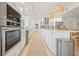 Bright kitchen boasts white cabinets, stainless steel appliances, an island with seating, and modern lighting at 204 75Th St, Holmes Beach, FL 34217