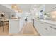 Modern kitchen features an island with bar seating, white cabinets, and stainless steel appliances for a clean and bright look at 204 75Th St, Holmes Beach, FL 34217