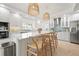 Bright kitchen boasts white cabinets, quartz countertops, island with seating, and stainless steel appliances at 204 75Th St, Holmes Beach, FL 34217