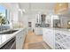 Bright kitchen features white cabinetry, stainless steel appliances, and a stylish island with wine rack at 204 75Th St, Holmes Beach, FL 34217