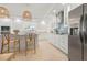 Well-lit kitchen features white cabinets, modern appliances, stainless steel refrigerator, and a decorative tile backsplash at 204 75Th St, Holmes Beach, FL 34217