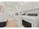Bright laundry room featuring modern washer and dryer units and convenient built-in storage at 204 75Th St, Holmes Beach, FL 34217