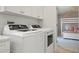 Well-lit laundry room featuring a modern washer and dryer with bright white cabinets at 204 75Th St, Holmes Beach, FL 34217