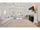 Bright and airy living room with neutral decor, tray ceiling, and cozy fireplace with mounted TV at 204 75Th St, Holmes Beach, FL 34217