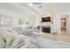 Bright living room with tray ceilings, modern fireplace, large windows, and stylish neutral furniture at 204 75Th St, Holmes Beach, FL 34217