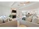 Open-concept living area with tray ceiling, modern fireplace, and seamless flow into the dining and kitchen spaces at 204 75Th St, Holmes Beach, FL 34217