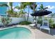 Private backyard pool with lounge chairs and lush tropical landscaping, creating a serene oasis at 204 75Th St, Holmes Beach, FL 34217