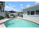 Inviting backyard pool area with lounge chairs, an umbrella, dining table and a privacy fence at 204 75Th St, Holmes Beach, FL 34217