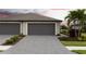 Garage and driveway featuring a paved driveway and well-kept landscaping at 2193 Bonito Way, Port Charlotte, FL 33953