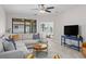 Cozy living room featuring a comfortable sectional, ceiling fan, and backyard views at 2193 Bonito Way, Port Charlotte, FL 33953