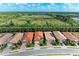 Aerial shot of several homes with red tile roofs, with a lush green landscape in the background at 224 Soliera St, Nokomis, FL 34275