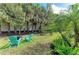 Green backyard area with mature landscaping, outdoor seating and a grill at 224 Soliera St, Nokomis, FL 34275