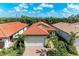 Charming single-Gathering home featuring a terracotta tile roof, brick driveway, and lush landscaping at 224 Soliera St, Nokomis, FL 34275
