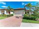 Inviting single Gathering home with a terracotta tile roof and a brick driveway, nestled in a lush green landscape at 224 Soliera St, Nokomis, FL 34275