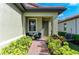 Cozy front porch with outdoor seating surrounded by vibrant, lush landscaping and a brick walkway at 224 Soliera St, Nokomis, FL 34275