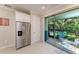 Kitchen with stainless steel refrigerator and sliding glass doors to screened patio and outdoor views at 224 Soliera St, Nokomis, FL 34275