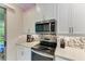 Clean kitchen features updated appliances, sleek white cabinets, and tiled backsplash at 224 Soliera St, Nokomis, FL 34275