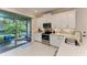 Bright kitchen features stainless steel appliances, white cabinets, and a view of the screened-in patio at 224 Soliera St, Nokomis, FL 34275