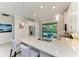 Bright kitchen featuring white cabinets, an island with seating, and backyard access at 224 Soliera St, Nokomis, FL 34275