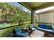 Screened-in patio area with cushioned wicker furniture and views of the tropical backyard at 224 Soliera St, Nokomis, FL 34275