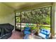 View of screened-in patio featuring wicker furniture, a grill and lush landscaping at 224 Soliera St, Nokomis, FL 34275