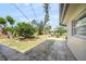 Beautiful backyard featuring a brick fireplace, mature trees, and a neatly landscaped garden at 2551 Waneta Dr, Sarasota, FL 34231