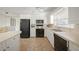Well-lit kitchen with white cabinetry, black appliances and ceramic tile flooring at 2551 Waneta Dr, Sarasota, FL 34231