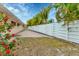 Fenced backyard with paver patio and beautiful red flowering plants at 3072 Meyer Dr, Sarasota, FL 34239