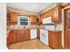 Functional kitchen with wooden cabinets, white appliances, granite countertops and a window above the sink at 3072 Meyer Dr, Sarasota, FL 34239