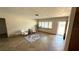 Bright living room with tile flooring, neutral paint, shuttered window, and an open doorway at 3072 Meyer Dr, Sarasota, FL 34239