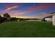 A large backyard featuring a view of the lake and sunset at 3210 Desert Plain Cv, Lakewood Ranch, FL 34211