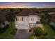 Charming two-story home features a tile roof, stone accents, and a well-manicured lawn with mature palm trees at 3210 Desert Plain Cv, Lakewood Ranch, FL 34211