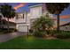 Beautiful two-story home boasting stone accents, a paved driveway, and lush landscaping with mature palm trees at 3210 Desert Plain Cv, Lakewood Ranch, FL 34211