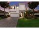 Inviting two-story home with a tile roof, stone details, a paved driveway, and manicured landscaping with palm trees at 3210 Desert Plain Cv, Lakewood Ranch, FL 34211