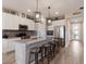 Modern kitchen with stainless steel appliances, a large island with seating, and stylish pendant lighting at 3210 Desert Plain Cv, Lakewood Ranch, FL 34211