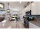 Bright kitchen with stainless steel appliances, a large center island, and an open view to the dining area at 3210 Desert Plain Cv, Lakewood Ranch, FL 34211