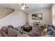 Comfortable living room featuring a large sectional sofa, a ceiling fan, and a wall-mounted TV at 3210 Desert Plain Cv, Lakewood Ranch, FL 34211